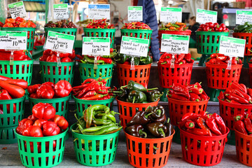 Fresh yellow, orange, green and red organic peppers capsicum on display for sale at local farmer's market departmental store.