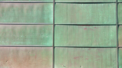 Fachada de placas de metal verdoso oxidado en edificio público grande