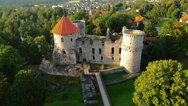 Drone shot of an old castle surrounded by trees in the Gauja National Park of Cesis in Latvia
