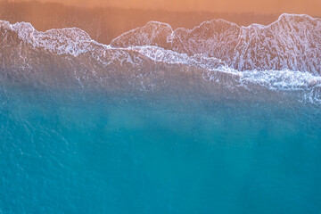Fototapeta na wymiar Turquoise water with wave with sand beach background from aerial top view. Concept summer sunny travel image