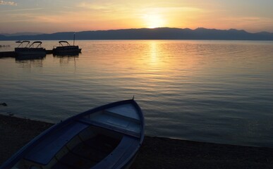 sunset on the shore of the lake and a boat