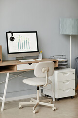 Vertical background image of minimal home office workplace in white with computer on wooden desk, copy space