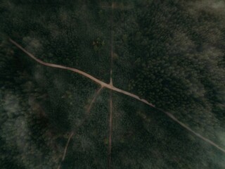 Aerial view of highway roads between forests on a foggy day perfect for wallpapers and backgrounds