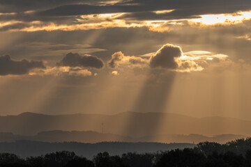 Beams of light of sun's rays through clouds in morning.