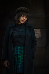 Portrait of a young beautiful dark-haired girl in an urban environment.