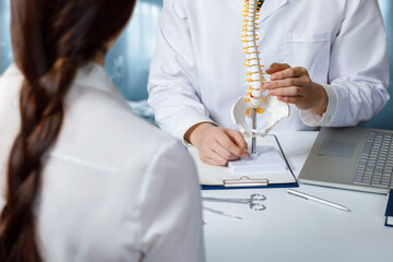 Doctor consulting a patient about diseases of the spine .
