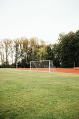 Vertical shot of a football field and goal net on a sunny day
