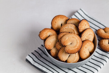 Bowl with fresh danish butter cookies on a striped napkin. Copy space.