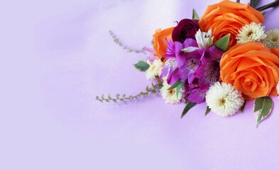 Bouquet with orange roses on a lilac background. Festive flower arrangement. Background for a greeting card.