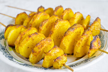 Baked potatoes, sliced into slices on skewers