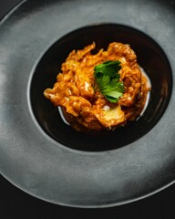 High-angle vertical shot of a fish gourmet served in a black bowl