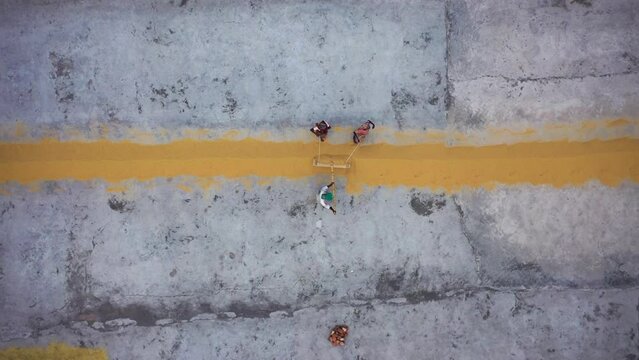 Dhaka, Bangladesh - 10 November 2022: Aerial view of farmers working in a field drying rice on a rice field in Dhamrai.