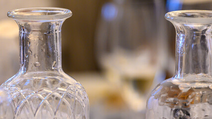 Two bottles of water - one sparkling the other flat. A glass of white wine in the distance between them.