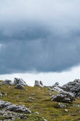 Vertical shot of the rocky meadow against the background of the cloudy sky.