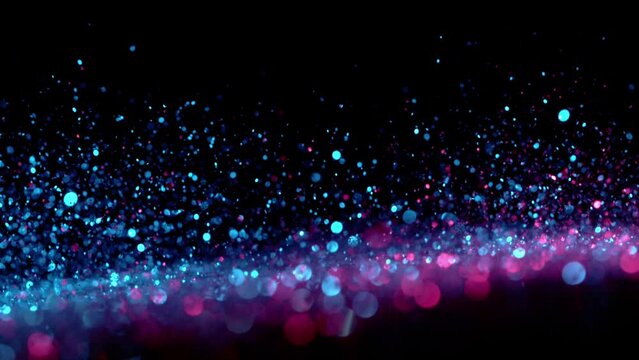 Super slow motion of sparkling abstract glittering background in neon colors. Filmed on high speed camera, 1000 fps.