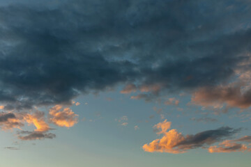 dark rain clouds backlit by the evening sun as a natural background