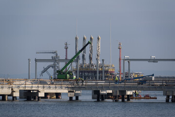 LNG TERMINAL - Workers and construction machinery on a gas terminal building site 
