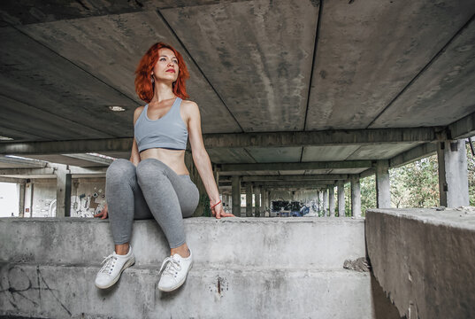 girl in sport clothes and her sole shoe from under. sporty female exercise on bridge background. low angle shutting.