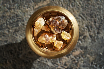 Frankincense or boswellia resin crystals on an incense burner, top view