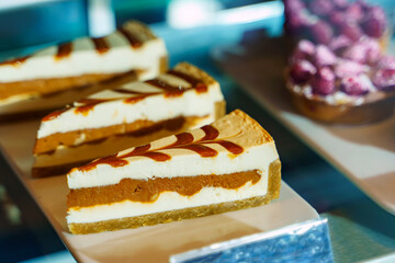 Caramel cheesecake lies on the counter next to other cakes