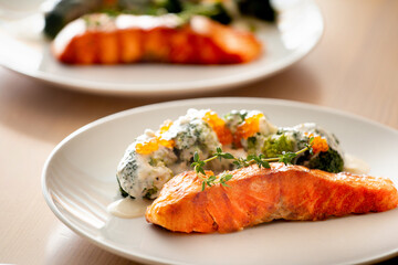 Salmon steak with broccoli on a white plate.