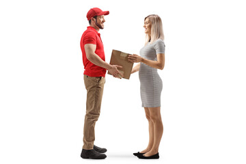 Full length profile shot of a young woman taking a cardboard box from a delivery man