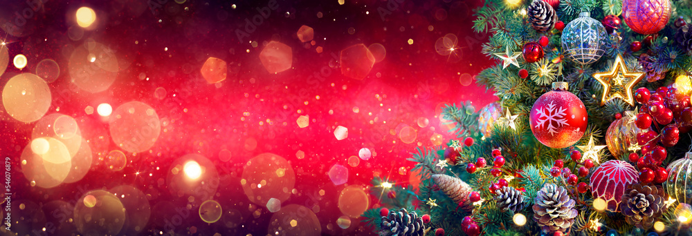 Wall mural christmas tree in red shiny background - ornaments on fir branches with glittering and defocused abs
