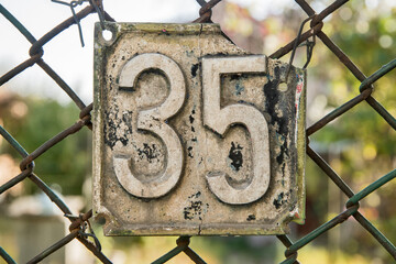 Old retro weathered cast iron plate number 35 closeup