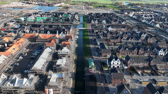 Building and construction of modern suburb housing. Scaffolding residential properties exterior urban development project. Houses in the Netherlands. Aerial drone view.