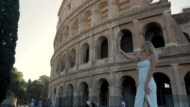 Young beautiful girl taking a selfie near the Colosseum, Rome Italy