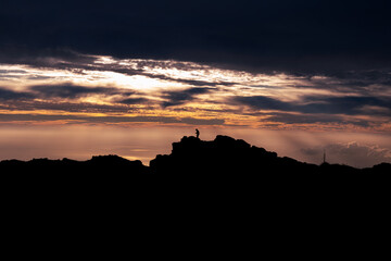 Persona viendo el atardecer sobre las montañas