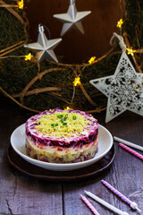 Dressed herring, raditional Soviet festive salad of herring and vegetables in a New Year's decoration.