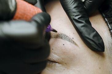 Correction with permanent make-up of woman's eyebrows.