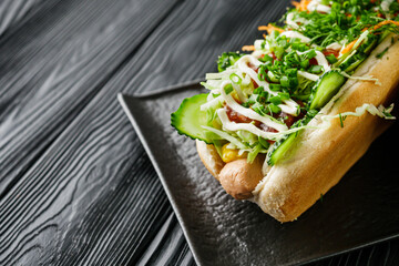 vegetarian sausage hot dog on a black rustic wooden background