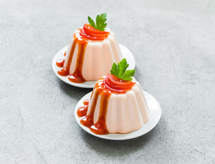 Vegan Cherry Tomato cream pudding, Panna Cotta with sauce, on a plate. Light gray background