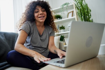 Pregnant woman smile sits at home on the couch with a laptop and talks with a doctor on video chat, freelancer works online. Lifestyle of a pregnant woman, preparation for childbirth communication