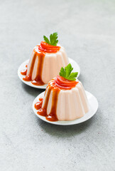 Tomato cream pudding, Panna Cotta with sauce, on a plate. Light gray background