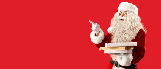 Santa Claus holding boxes with tasty pizza and pointing at something on red background with space...
