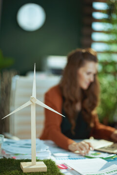 Wind turbine woman with laptop working in green office