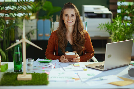 happy elegant business owner woman in green office