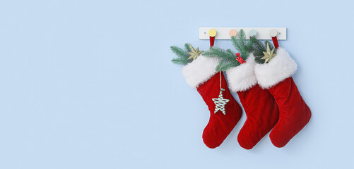 Beautiful Christmas socks hanging on light blue wall