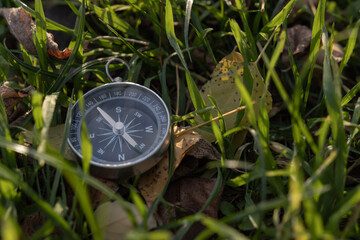 Compass for tourism lies in the grass. Concept of travel and discovery