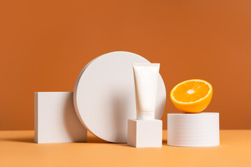 Front view mockup scene with unbranded white cosmetic tube on white podium and orange on beige...