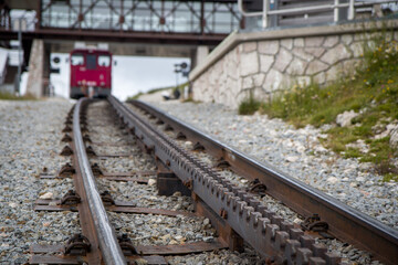 Fototapeta premium Schafbergbahn Cog Railway running from St. Wolfgang up the Schafberg, Austria. Journey to the top of Alps through lush fields and green forests. Focused detail with blurred background and foreground.