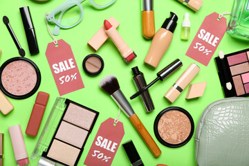 Fototapeta premium Bag with cosmetics, accessories and sale tags on green background