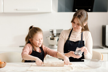 Mom teaches her little daughter 10 years old how to bake cookies. Cooking Homemade Cookies. High quality photo