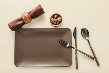 Table setting and bowl with walnuts on light background