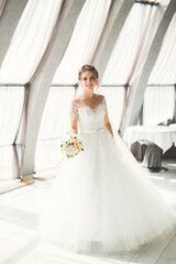 Portrait of stunning bride with long hair posing with great bouquet