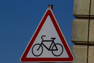 Cycle route ahead warning sign with a blue sky