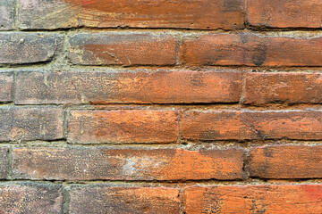 brick wall of red color, wide panorama of masonry. Old brick wall with shadow texture. cracked bricks, with a weathered and faded surface. Restored brickwork of an old house.